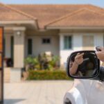 The Benefits of Having an Automatic Gate for Families A person driving a silver car pushes the button on a remote that opens an automatic gate for their home's driveway.