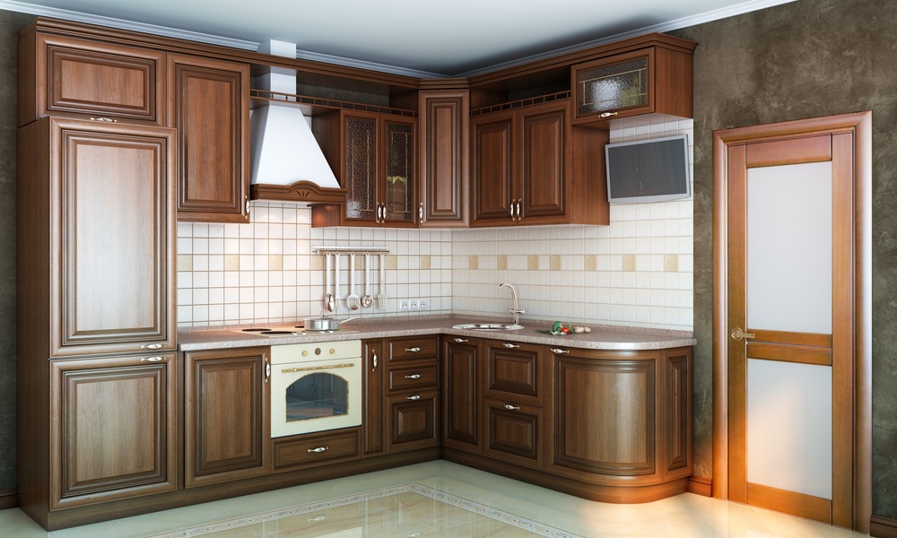 A newly remodeled kitchen with dark wooden cabinets, a tiled backsplash, a wall-mounted TV, and shiny flooring.